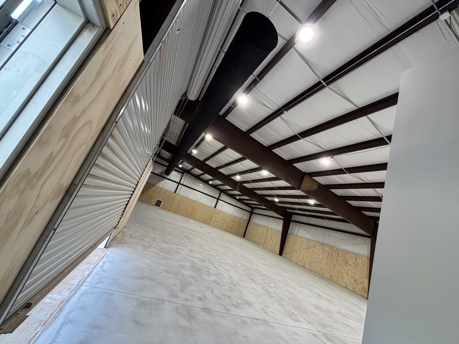 Interior of a completed steel building with a finished concrete floor and exposed roof framing