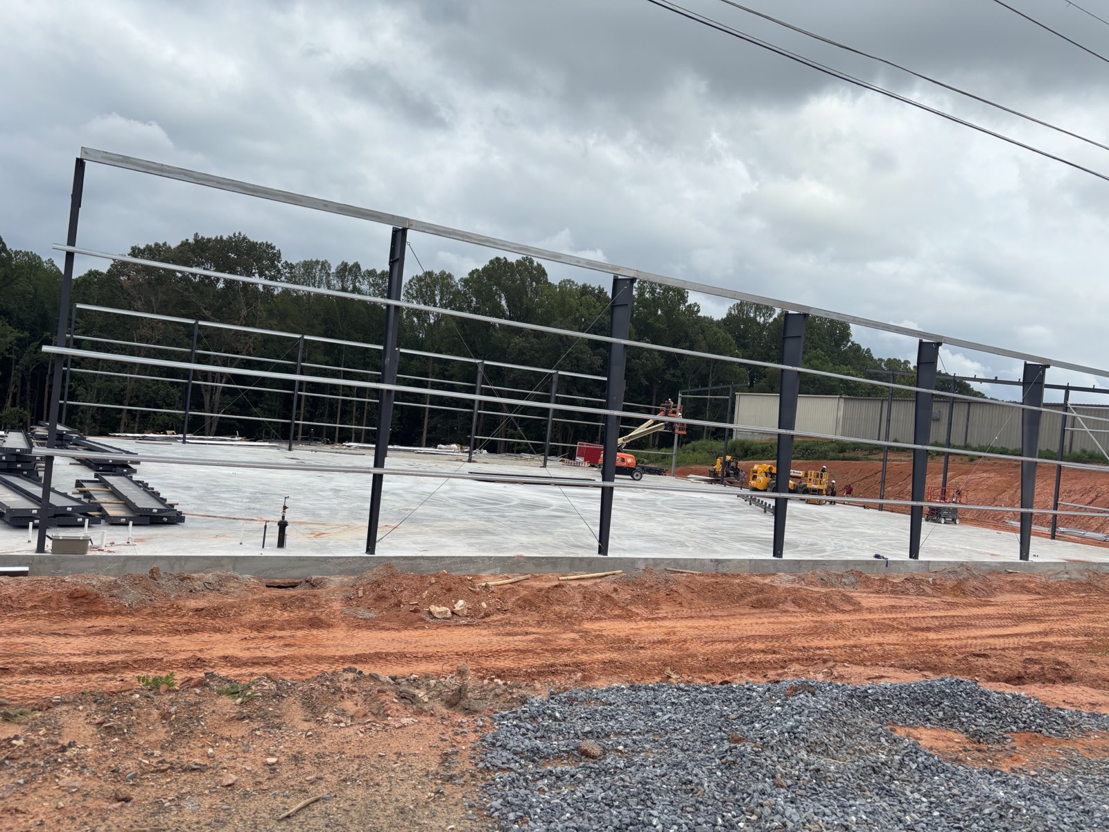 Structural steel frame going up over a finished concrete slab on an Oxen Civil commercial building pad