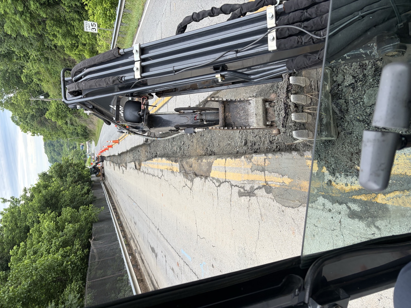 Excavadora abriendo una zanja de servicios en el acotamiento de una carretera