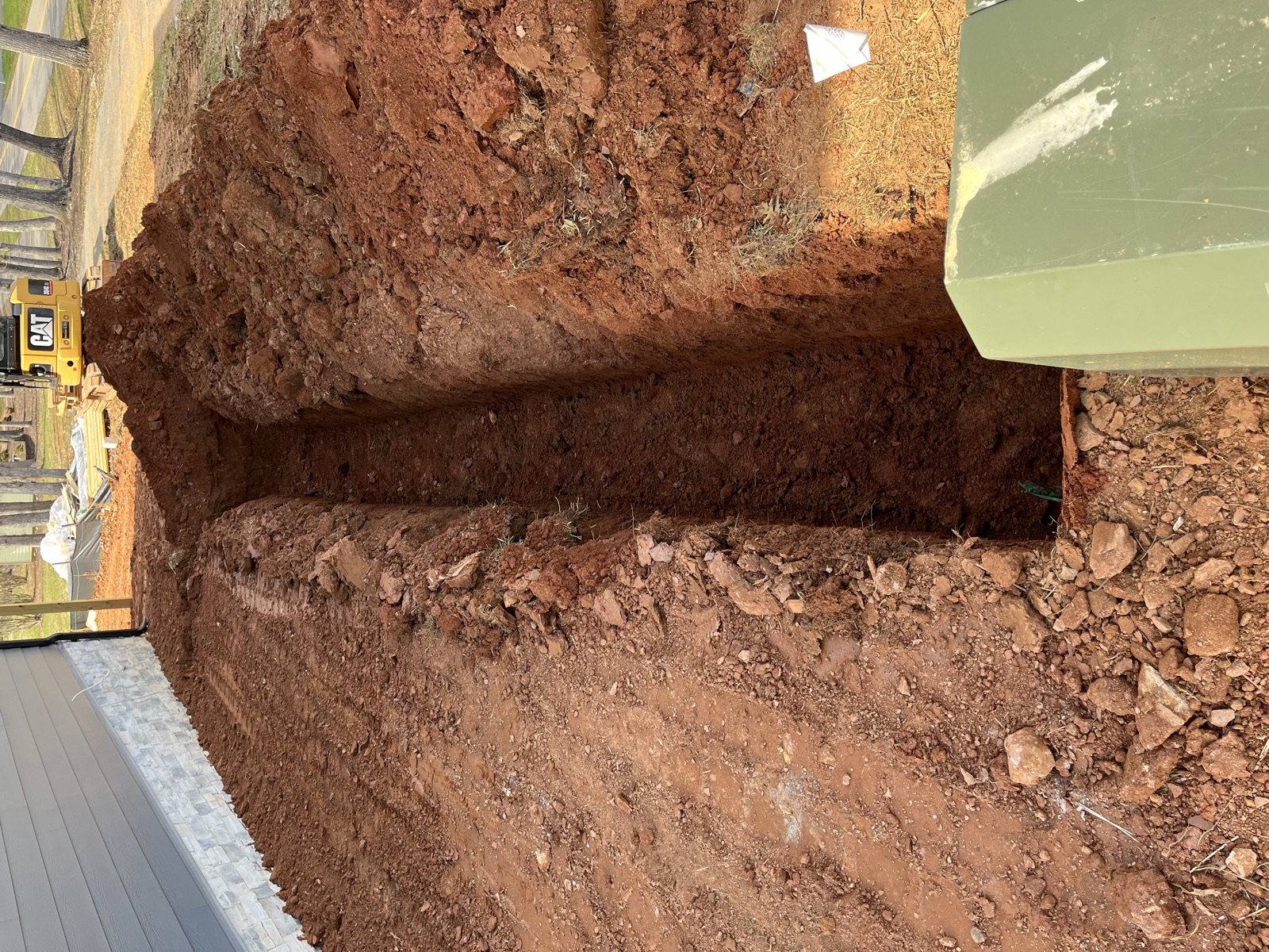Zanja profunda de servicios excavada junto a los cimientos de una casa