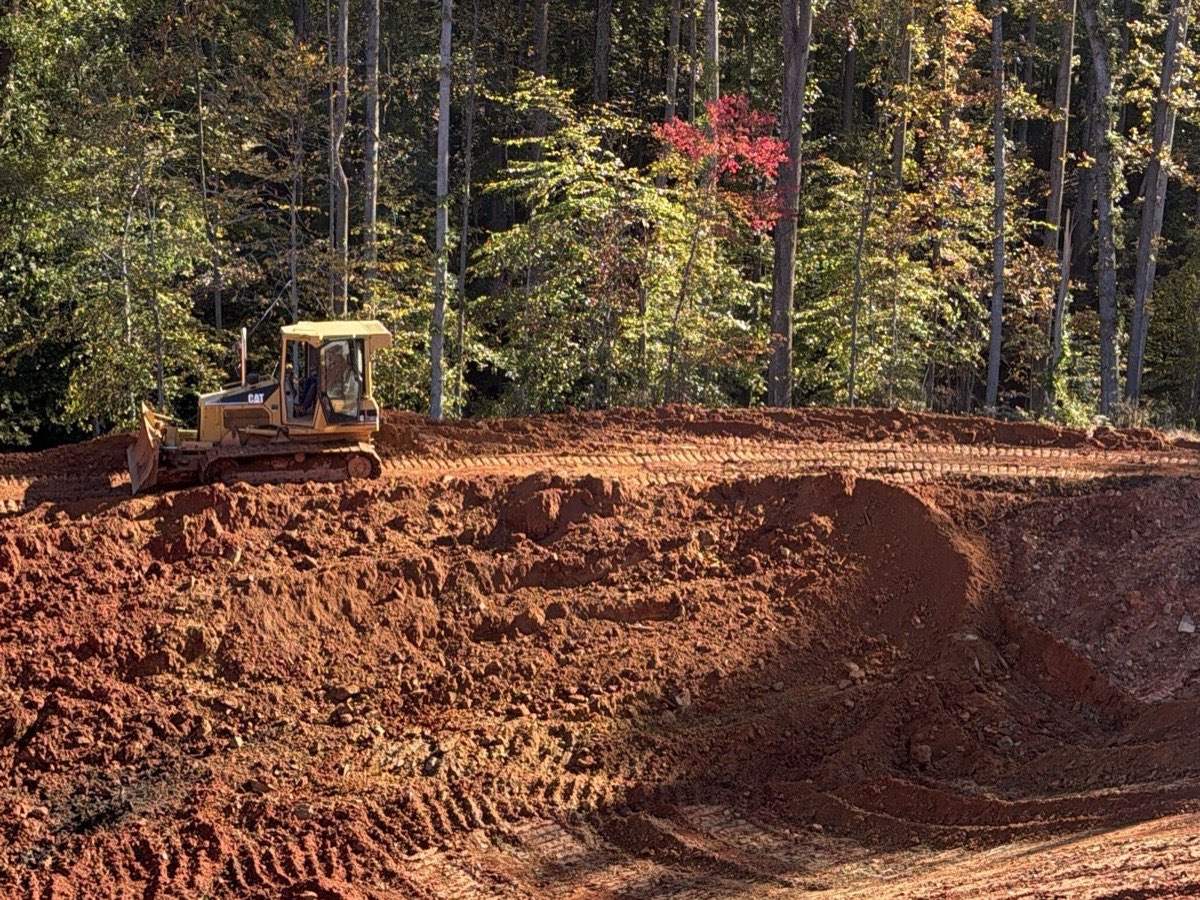 Oxen Civil CAT dozer cutting and shaping a red-clay bank on a site work project near Lynchburg, VA